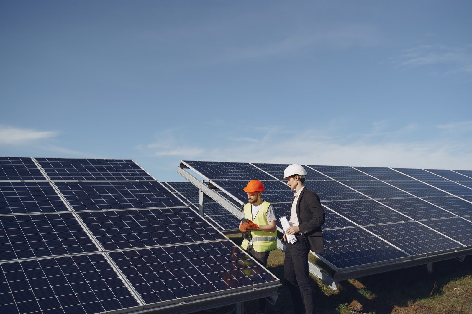 Equipe técnica da Cristal - Engineering, Procurement & Construction analisando projeto ao lado de painéis solares